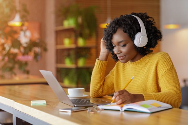 Off campus female wearing headphones studying